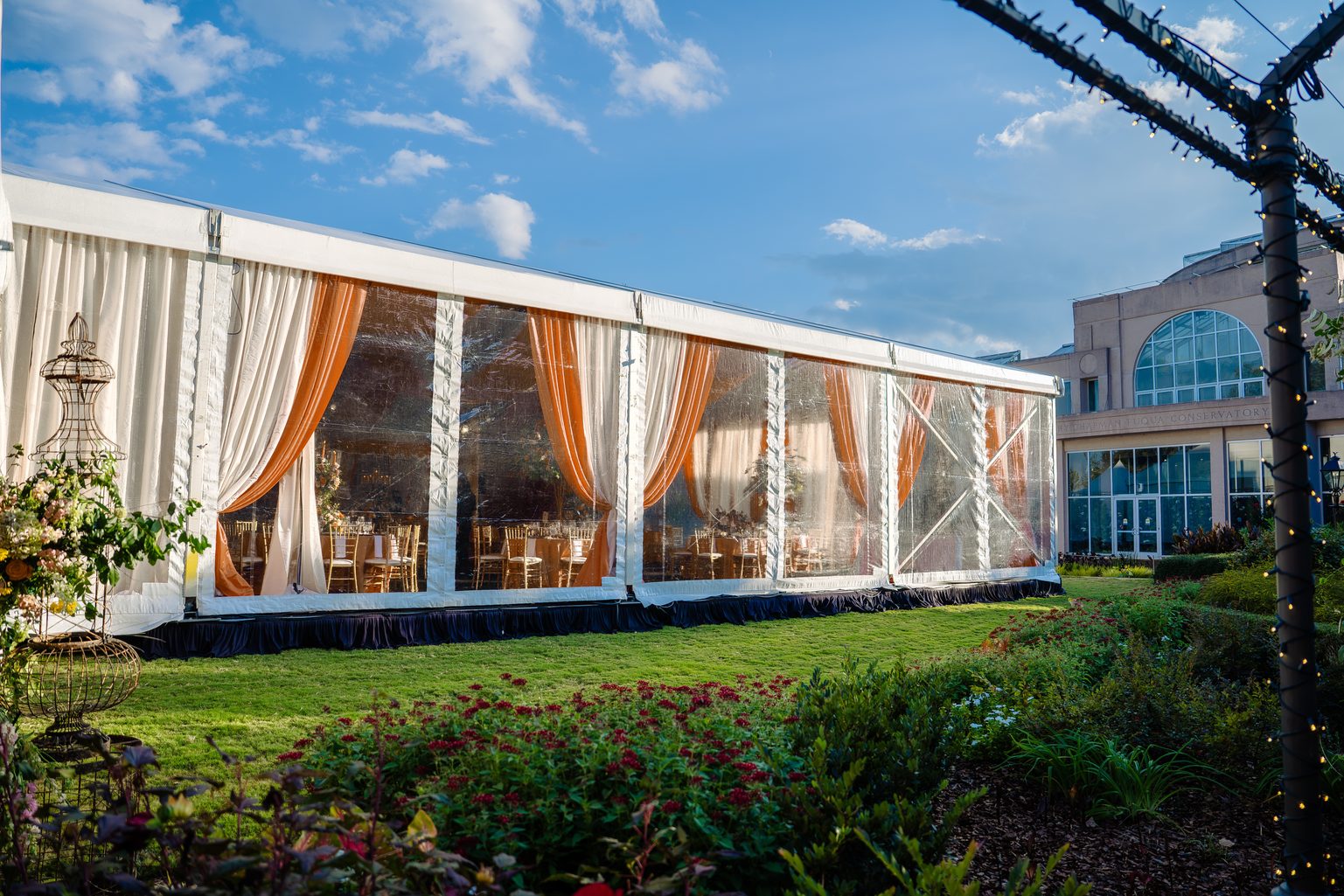 Clear sidewall structure tent with cream and orange draping set up for a fall event in Atlanta