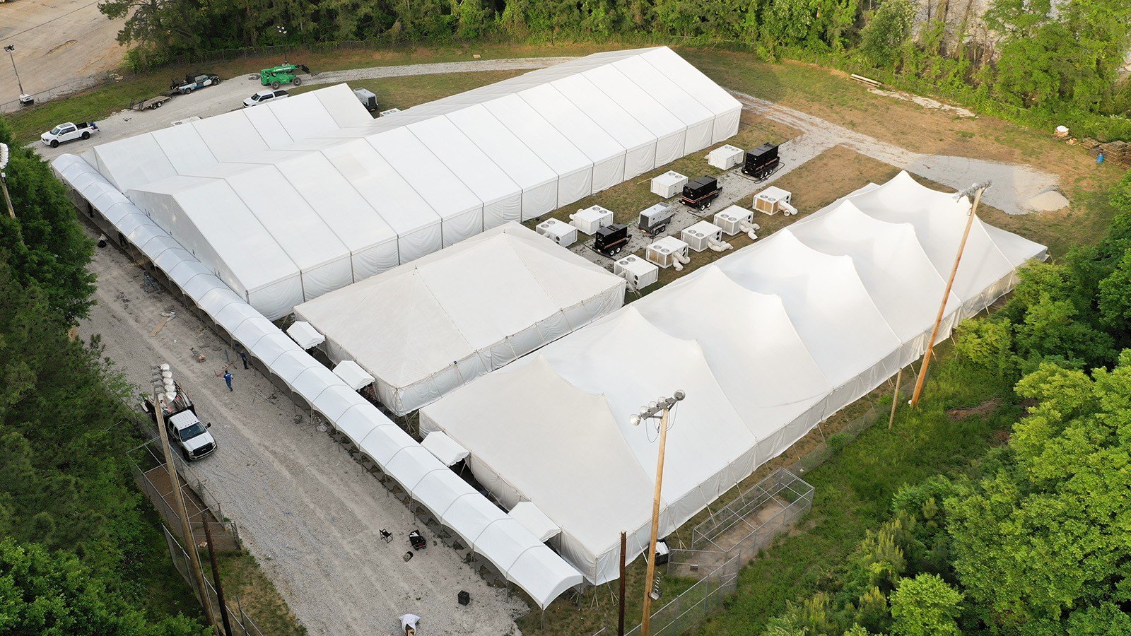 Aerial view of large white clearspan construction tents with commercial HVAC units on a job site